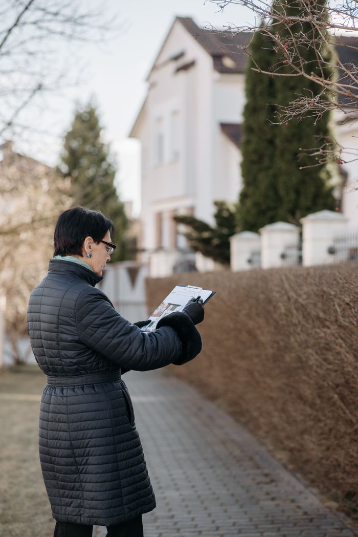 Crafting Captivating Headlines: Your awesome post title goes here A real estate agent examines house plans while standing outside.