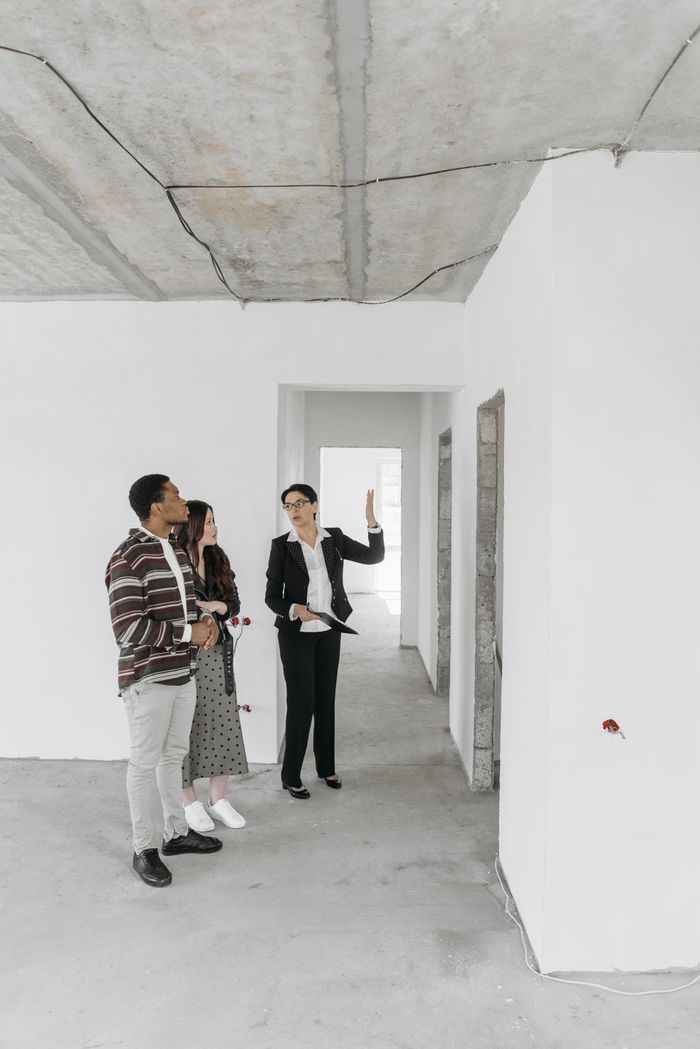 The Art of Drawing Readers In: Your attractive post title goes here A real estate agent shows an empty property to potential buyers in a modern style.